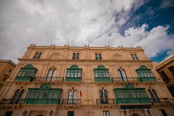 Beautiful house in the centre of Valleta city on Malta, vintage facade with green windows and ornaments.