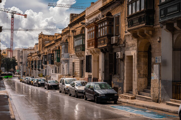 Obraz na płótnie Canvas Road in the city of Valletta packed with cars and other traffic. Typical street in the mediterranean island of Malta on a rainy sunny day.