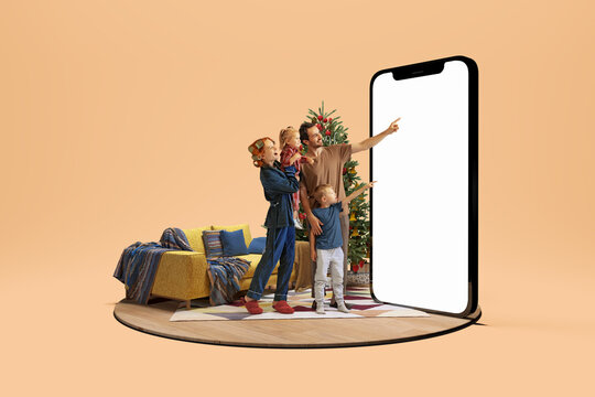 Christmas atmosphere at home. Happy family making order standing next to huge 3d model of smartphone with empty white screen isolated on yellow background. Online shopping