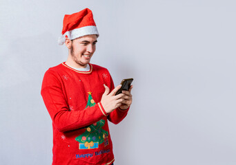 People in santa hat using and smiling at cellphone isolated, Smiling young man in christmas hat using cellphone isolated. Happy guy in christmas hat smiling at cellphone isolated