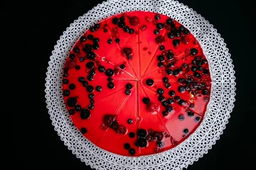 Foto op Plexiglas Top view of a cheesecake with berries and red jelly on a black background © Diego Ignacio Riquelme Alvarado/Wirestock Creators