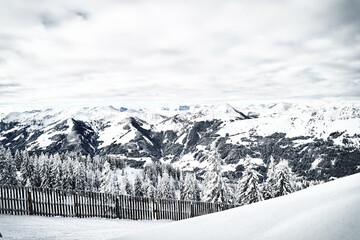 Panoramic view of winter mountains with snowy forest and frozen fence