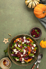 Warm winter quinoa salad with pumpkin, chorizo and mozzarella, arugula leaves and pomegranate.