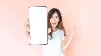 beautiful Asian young woman showing big smart phone with blank screen , white screen empty copy space for advertising banner isolated on pink background , Mock Up Image