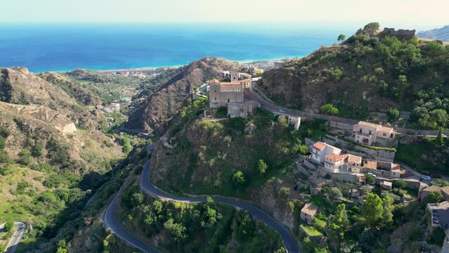 Drone view of the town of Savoca. In the distance, the church and the Mediterranean Sea. Sicily. Italy.