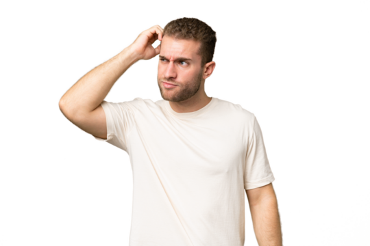 Young handsome caucasian man isolated on green chroma background having doubts while scratching head