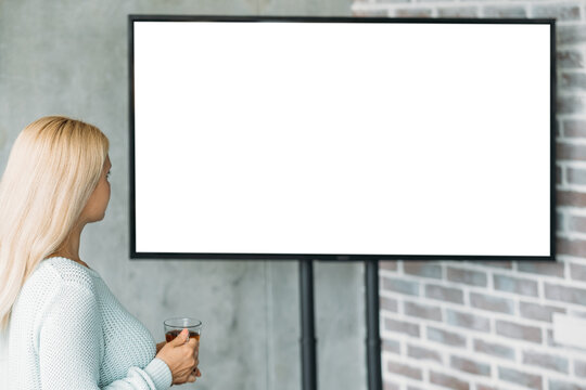 Virtual presentation. Digital mockup. Modern technology. Unrecognizable woman looking to projector blank screen staying light room interior.