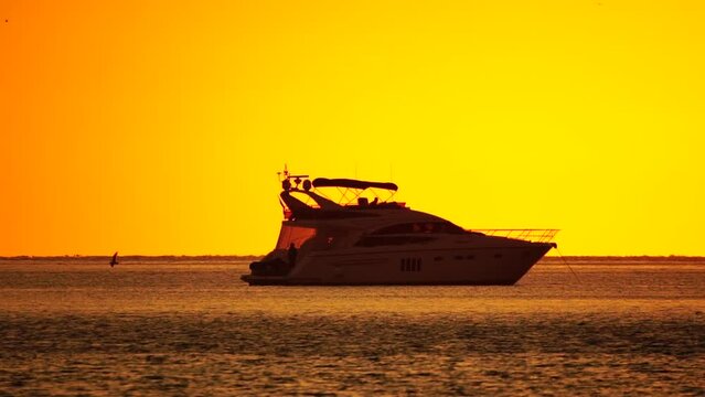 Luxury cruise trip. Red burning sunset over the sea with silhouette of rich yacht. Abstract nature summer ocean sea background. Summer journey on luxury ship