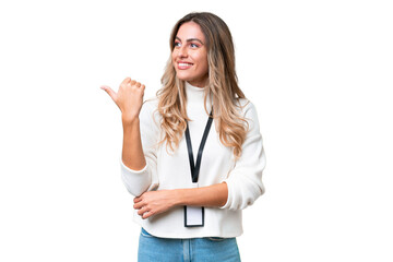 Young Uruguayan woman with ID card over isolated background pointing to the side to present a product