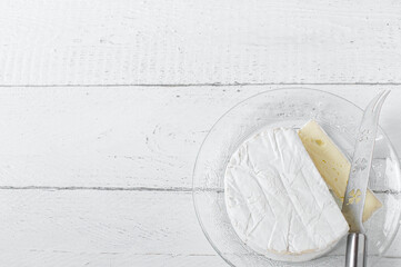 Soft cheese - french brie isolated on white background with knife. Side view with copy space