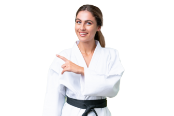 Young Uruguayan woman doing karate over isolated background pointing to the side to present a product