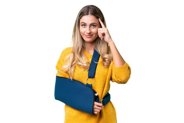 Young Uruguayan woman with broken arm and wearing a sling over isolated background thinking an idea