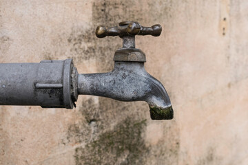 Old Metal Water Spigot on Concrete Wall