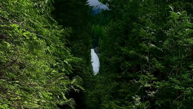 Washington State Waterfall From A Distance Surrounded By Greenery. Was Taken At Wallace Falls Hike On A First Waterfall Trail