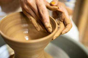 陶芸家の作業をする手のクローズアップ