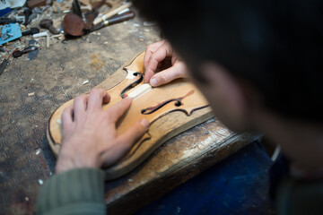 Fototapeta na wymiar Luthier crée une cale pour un violon 