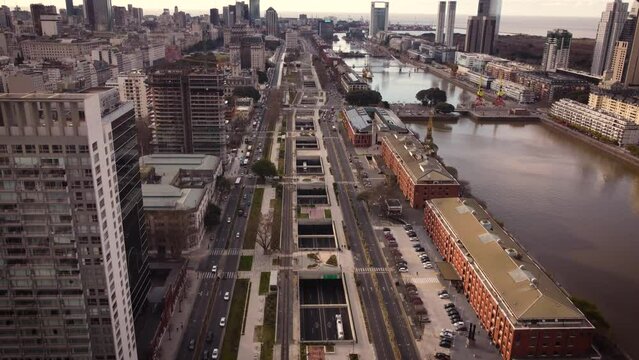 Aerial tilt up shot of traffic on road beside river in Puerto madero District druing sunset time - Buenos Aires Capital of Argentina