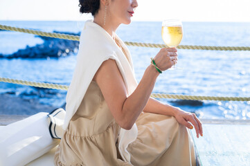 海辺のレストランでビールを飲む女性