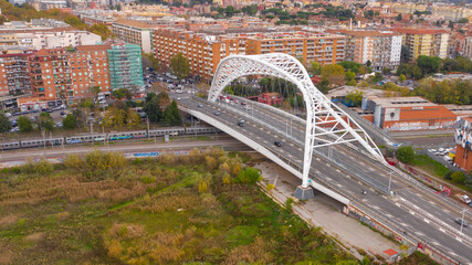 Fototapeta premium Aerial view of the Settimia Spizzichino bridge known as Ostiense overpass. This iron arch bridge is located in the Garbatella district in Rome, Italy