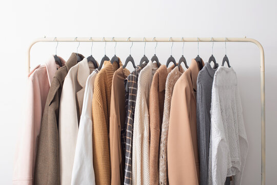 female autumn clothes on hangers  in  white room
