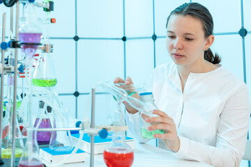 young woman in a chemical laboratory analyzes the water from the river for the presence of toxic substances