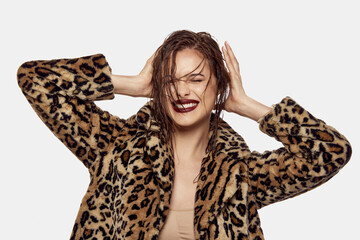 Portrait of young beautiful girl posing in stylish animal print coat and wet hairstyle look,...