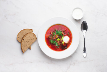 Ukrainian and Russian, Lithuanian, Belarusian and Polish traditional beetroot soup  borscht in bowl in an elegant white plate. Traditional cuisine of the Slavic countries, top view