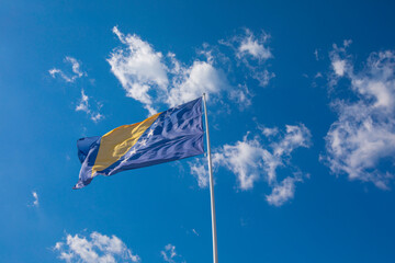 Flag of Bosnia and Herzegovina rise waving to the wind with sky in the background