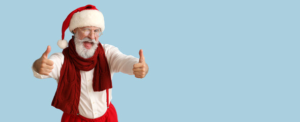 Cool Santa Claus showing thumb-up on light blue background with space for text