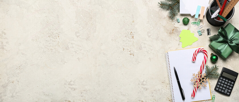 Office stationery with Christmas decor and gift on grunge background with space for text