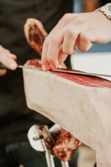 Profesional slicing Spanish jamon iberico (ham). Selective focus point