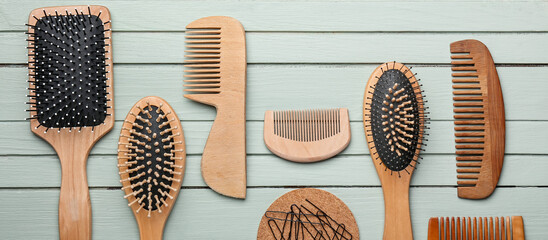 Set of hairdresser combs and brushes on wooden background, top view