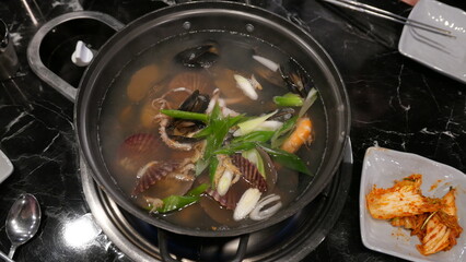 Seafood stew comprising shellfish and prawns in metal pan or pot