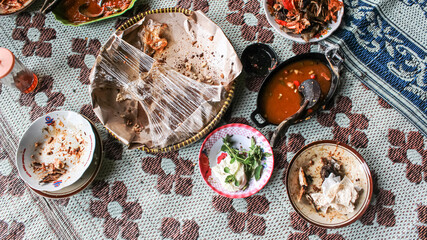 Empty dish plate with traces and pieces of food. Unfinished or finished lunch, dinner, breakfast bowl on table in kitchen. Dirty, empty, not clean. Spoon. Fork.