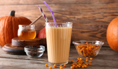 Glass of tasty pumpkin smoothie on wooden table