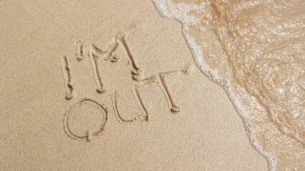 The word i'm out is writting on the sand with wave. drawing on the sand. writing with sands on the...