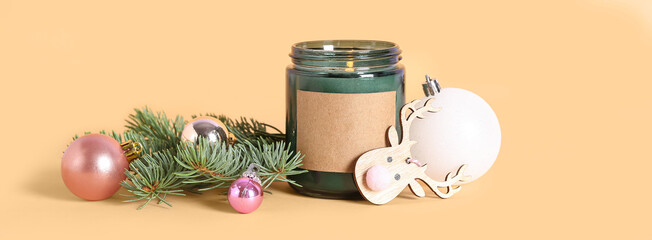 Jar with burning candle, Christmas decor and fir branches on beige background © Pixel-Shot
