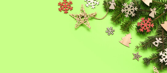 Fir branches and different Christmas decorations on green background with space for text