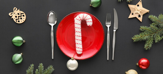 Beautiful table setting with Christmas decor and fur branches on black background