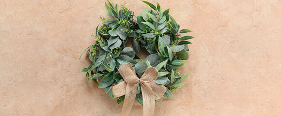 Stylish Christmas wreath on beige background, top view