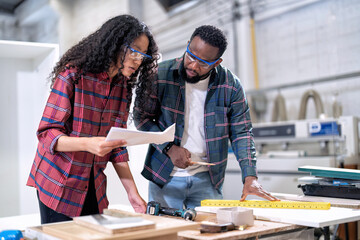 In wooden industrial senior carpenter teach trainee engineer use level ruler draw layout on wood