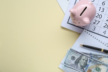 Flat lay composition with piggy bank and banknotes on beige background. Space for text