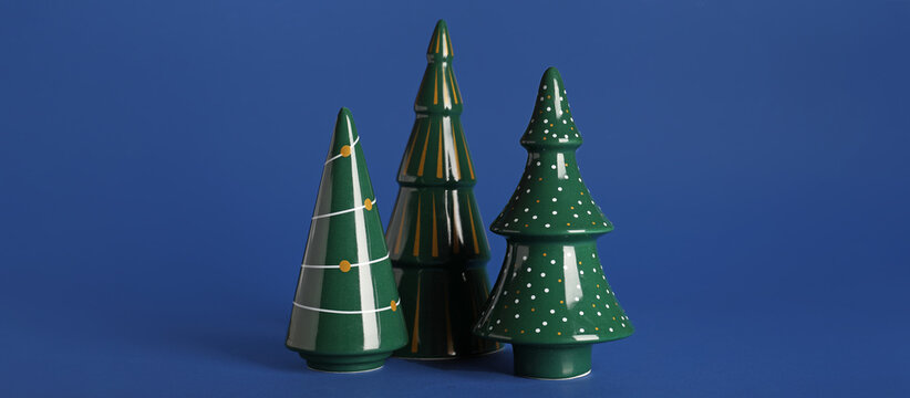 Ceramic Christmas trees on blue background
