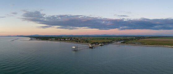 Aerial shot of fishing huts on shores of estuary at sunset,italian fishing machine, called...