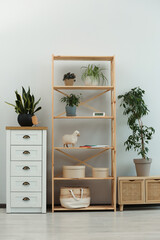 Stylish room interior with wooden furniture and beautiful green houseplants