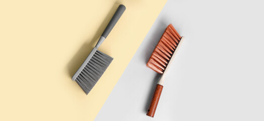 Dust brushes on color background, top view