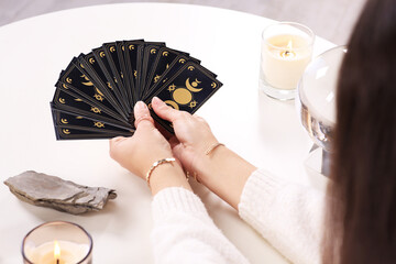 Soothsayer with tarot card at table, closeup