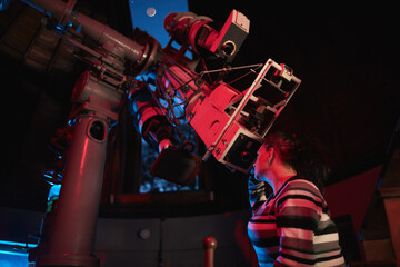 Astronomer with a big astronomical telescope in observatory doing science research of space and celestial objects. - obrazy, fototapety, plakaty