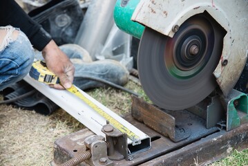Man doing metal work using hand cutting machine tool	