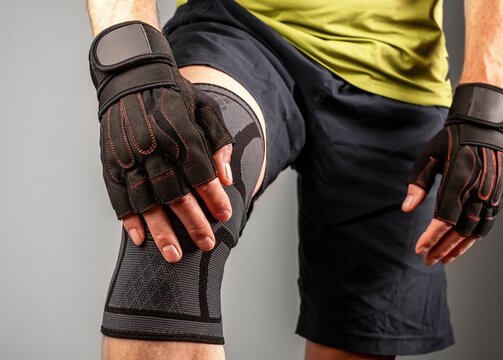 Athlete wearing knee support brace, elastic kneecap bandage, orthopedic sleeve for compression, protection